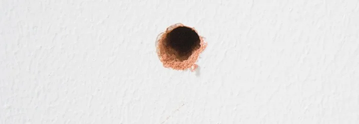 Ein Loch in einer weißen Wand.